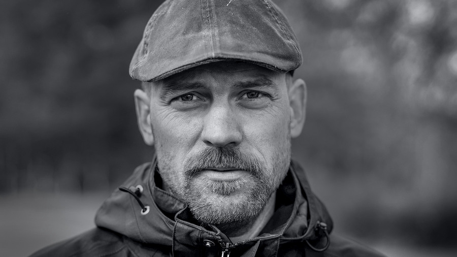 Albin Almevall kollar in i kameran med en basker på huvudet, svartvit profilbild