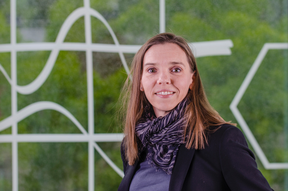 Porträtt av Karolina Parding framför en grön bakgrund