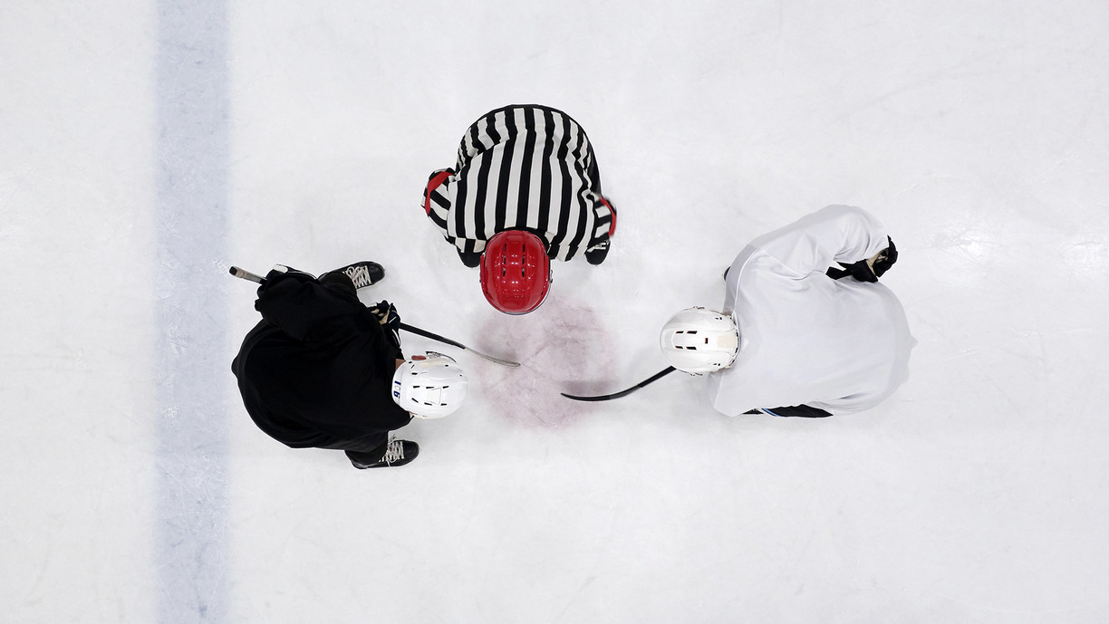 Two hockey players and a referee, seen from above