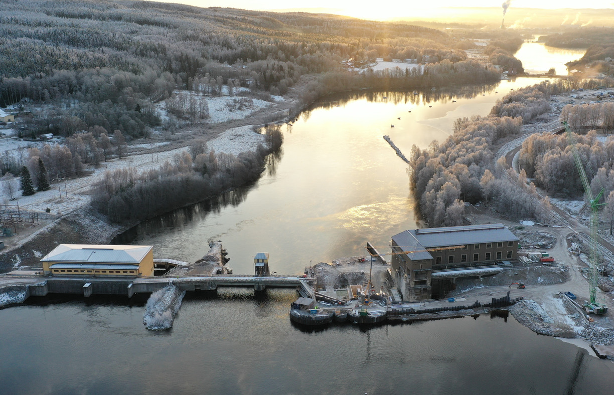 Ett vattenkraftverk över en flod i ett snöigt landskap