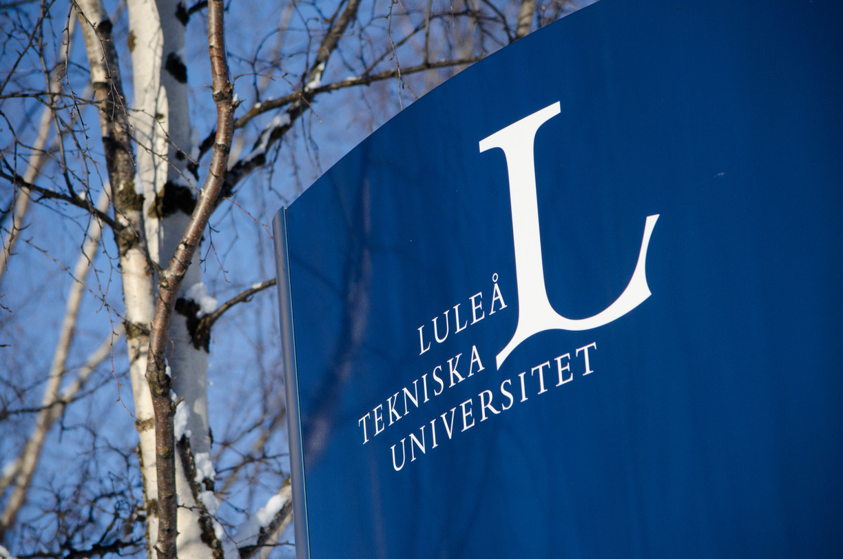 A sign with Luleå university of technology's logo, birch tree in background