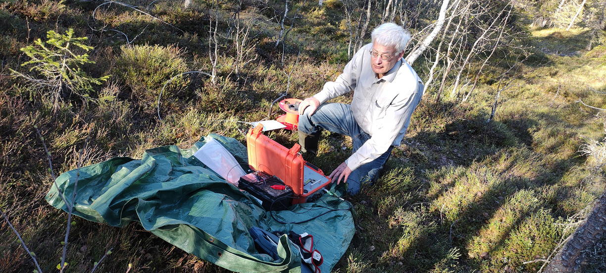 Thorkild Rasmussen sitting on the ground by some measuring equipment