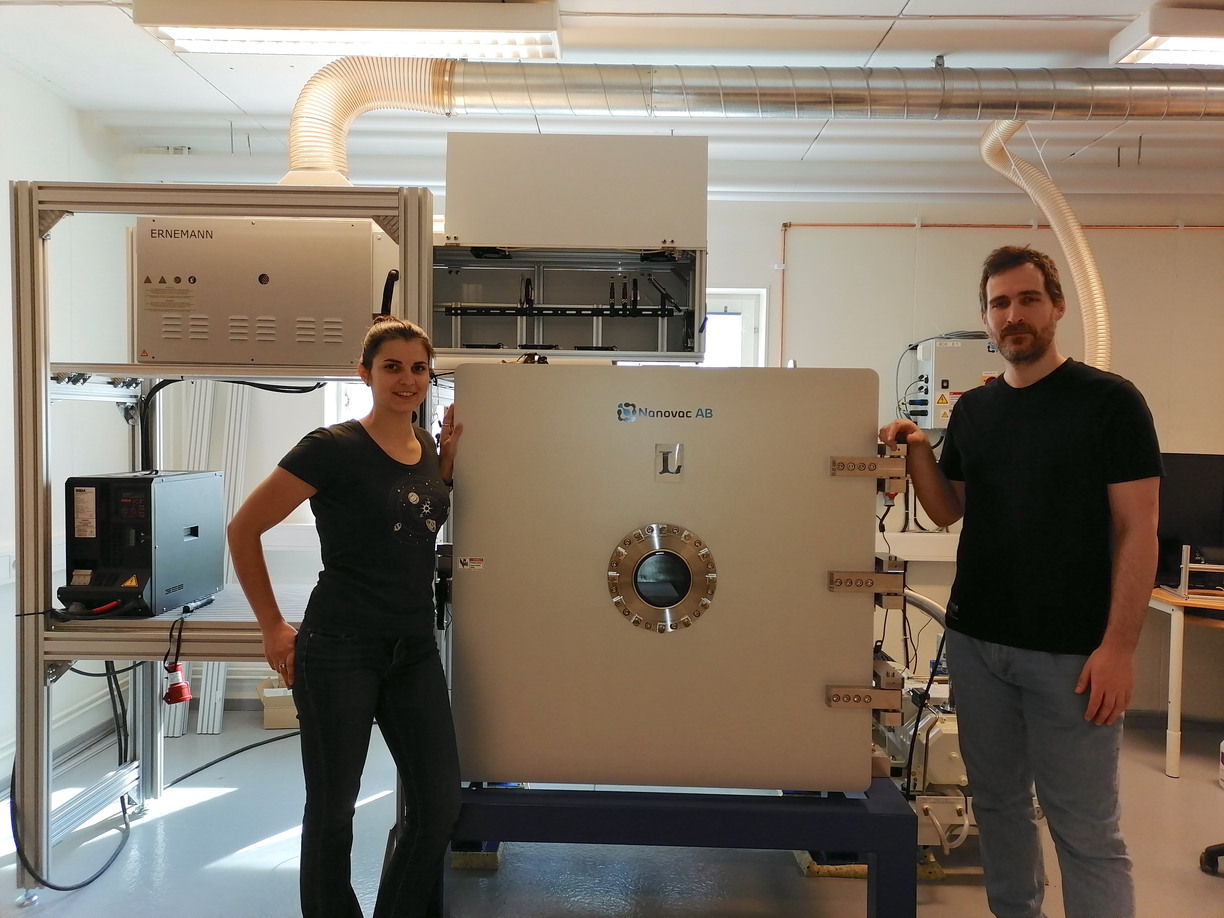 Athanasia Toliou and Georgios Tsirvoulis standing by a machine in a laboratory