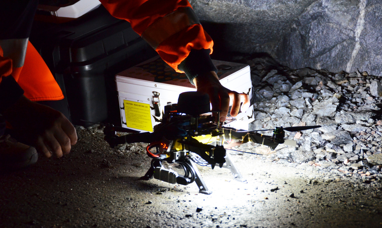 Closeup of a drone being held by a mine worker in a mine