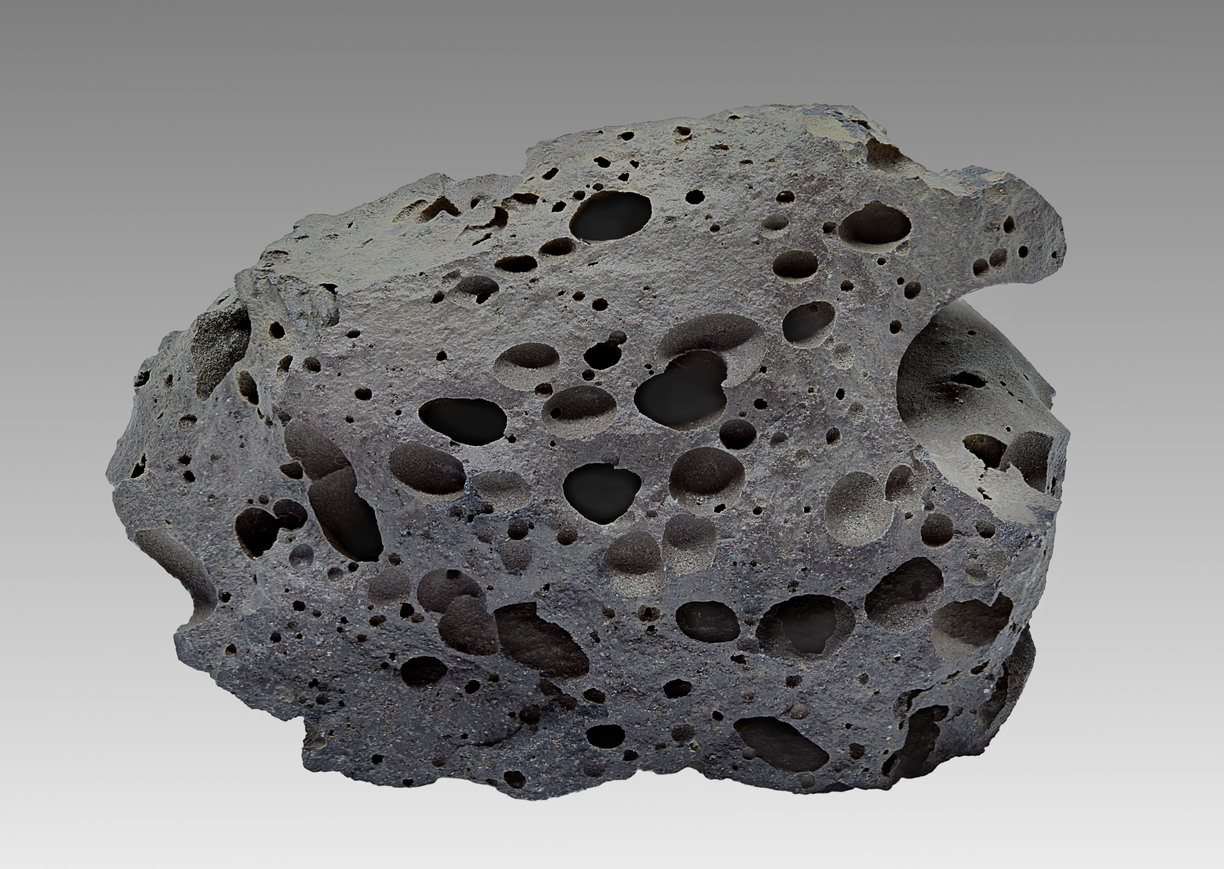 Basalt från Island. De ljusa mineralen mitt i bilden är kalcit som bildats av nedpumpad koldioxid
