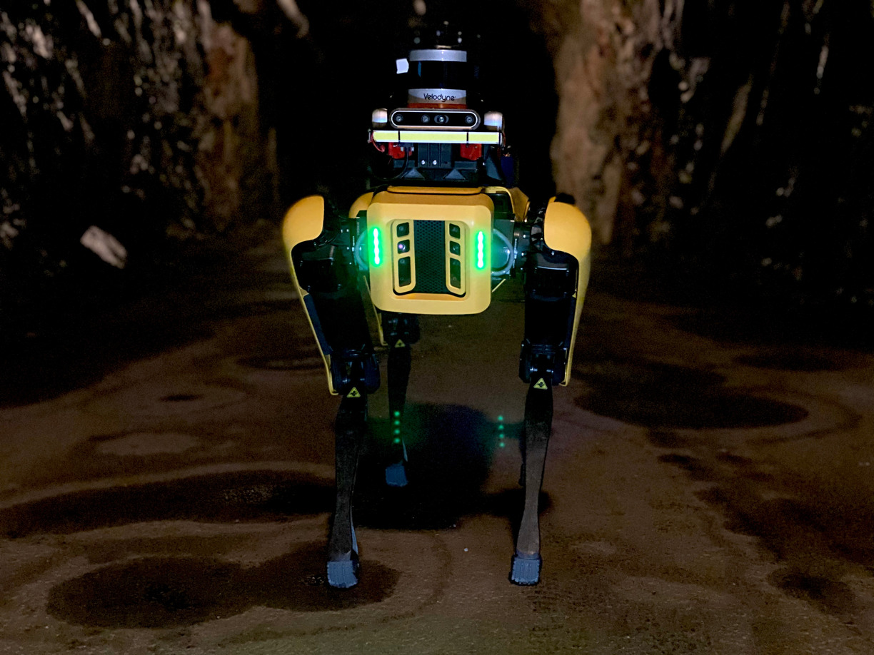 Fyrbent robot ståendes i en gruvtunnel