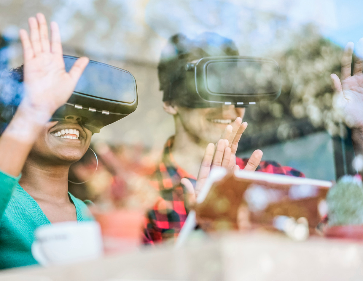 A man and woman waving with VR glasses on