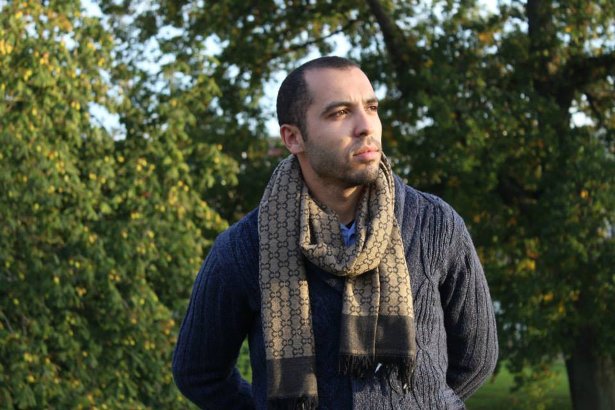 Hicham Baammi stående utomhus vid grönska