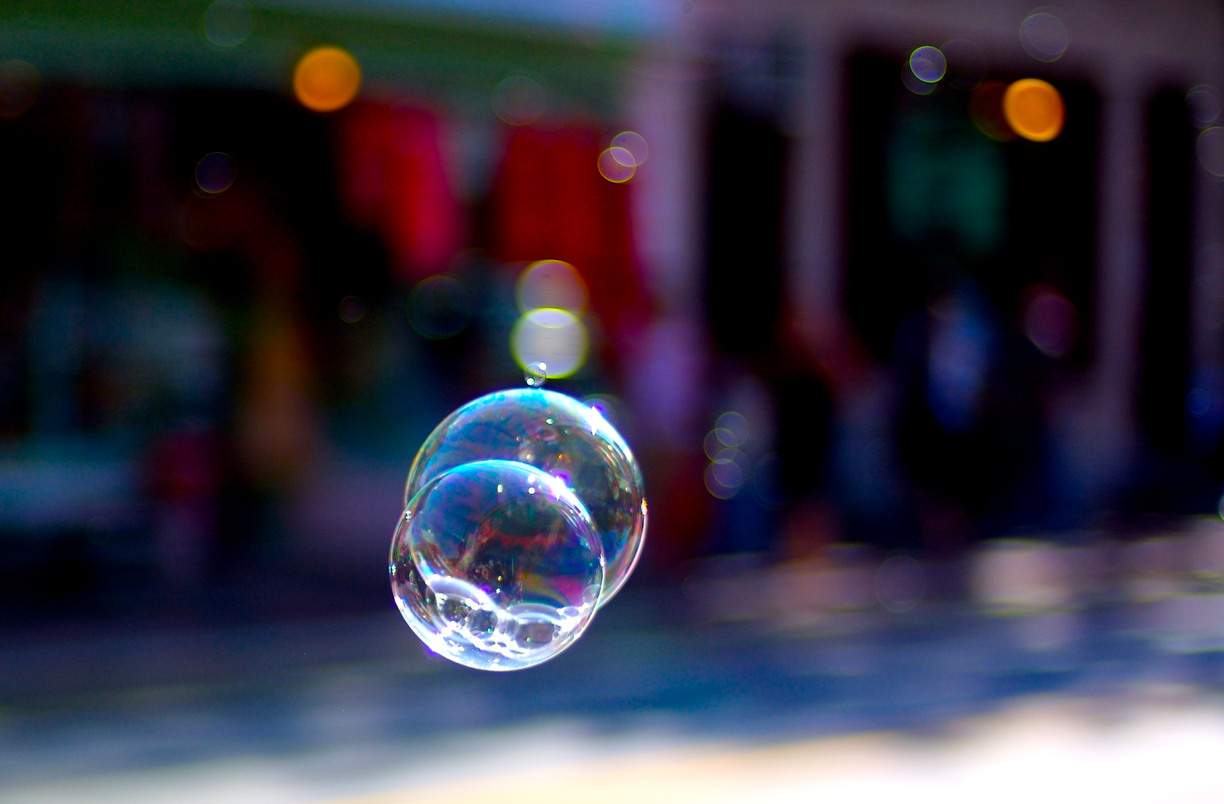 Soap bubbles in focus with exterior environment in background in blur
