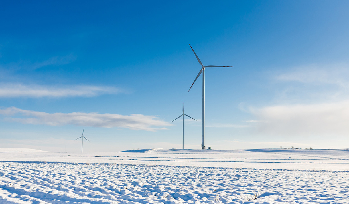 Wind turbines along a snowy horizon