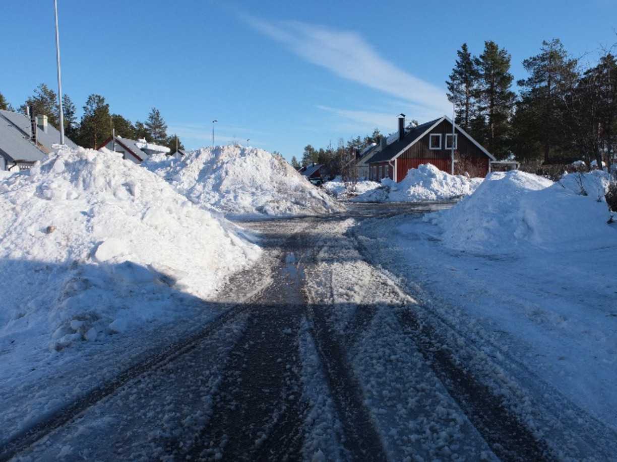Stora snöhögar i byn, vårsol i norra Sverige