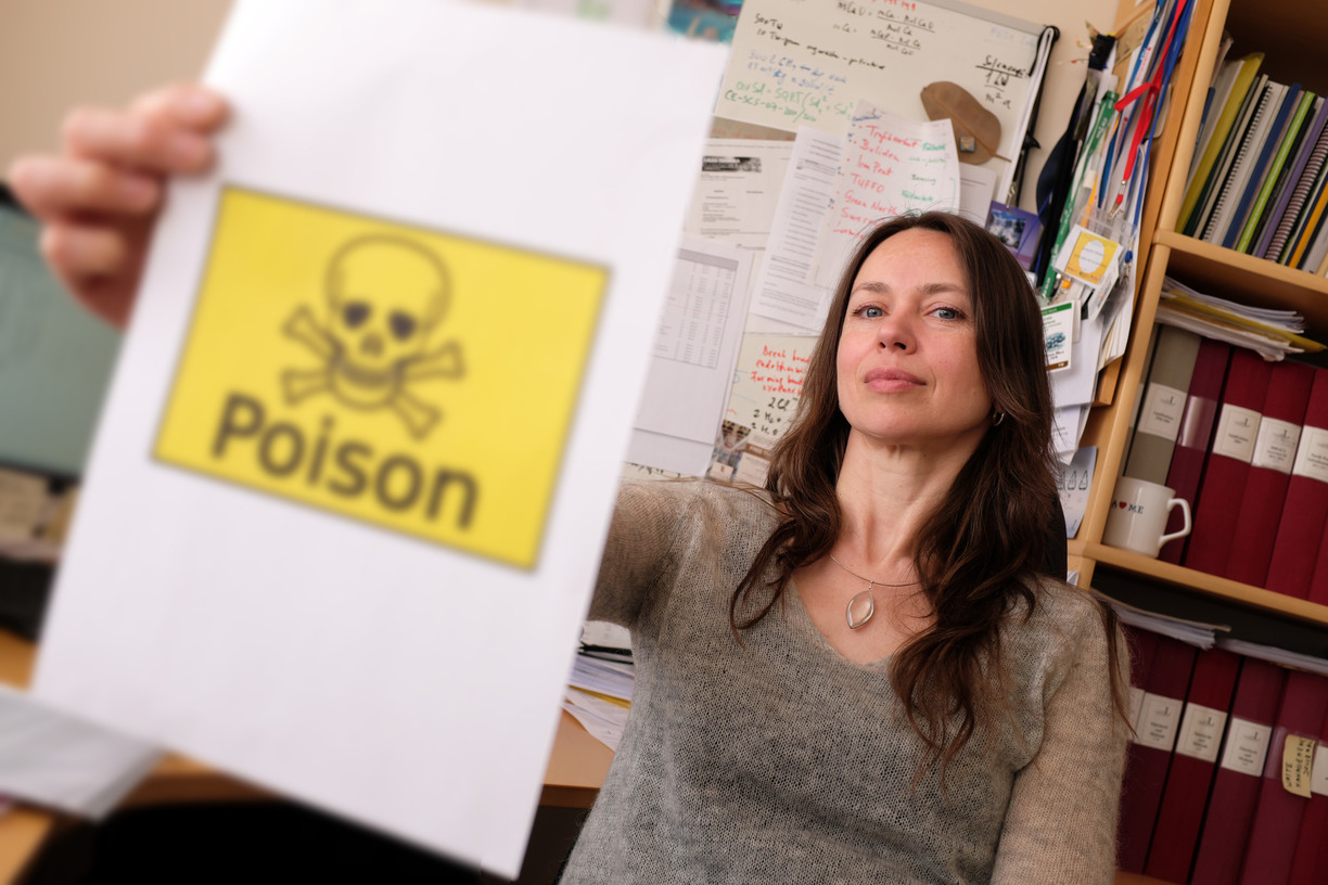 Close-up of a warning symbol for poison being held by Jurate Kumpiene